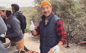 Mentor Joel Silva passes out doughnuts at one of the Boys to Men challenge adventure weekends. (Photo courtesy of Joel Silva)